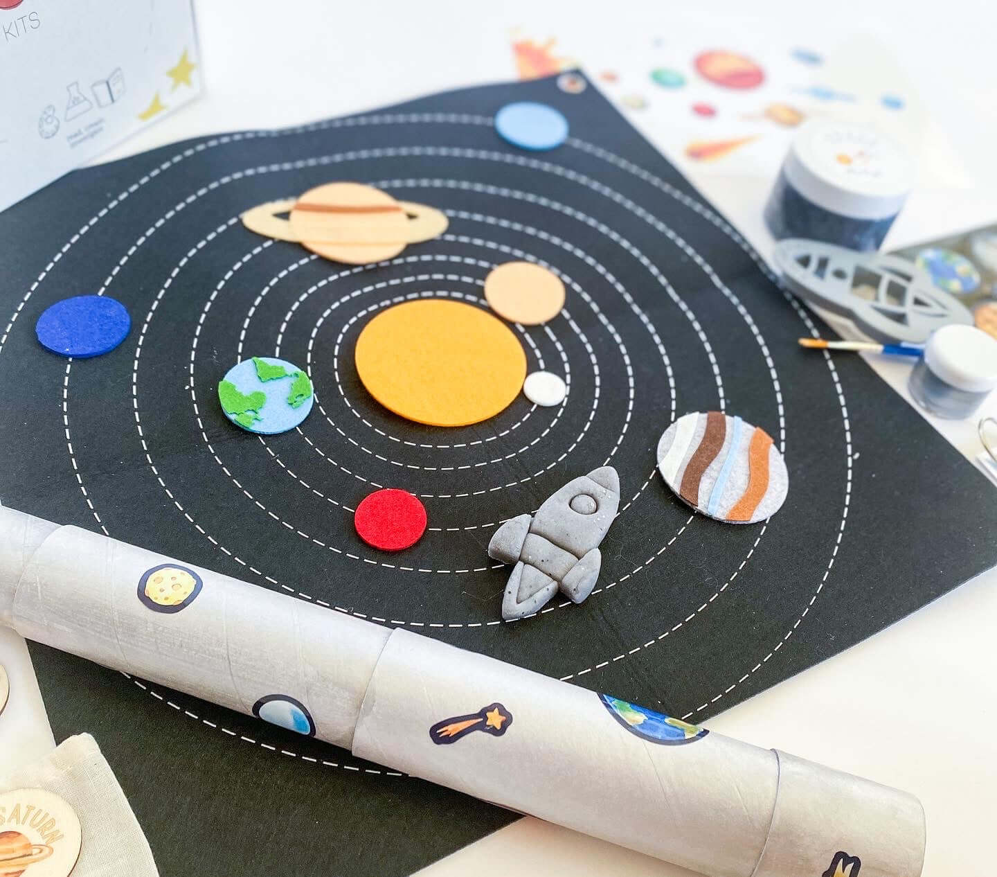 Space-themed play and learn kit for children with homemade playdough, rocket playdough cutter, and telescope activity. Includes wooden planet memory game, NASA name badge, and a box that transforms into a rocket backpack for hours of fun.